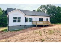 Newly built home with white siding, black shutters, and a wood deck at 118 Brett Will Ct, Taylorsville, NC 28681