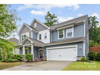 Charming two-story home featuring a two-car garage, manicured lawn, and inviting front porch at 15630 Oleander Dr, Charlotte, NC 28278