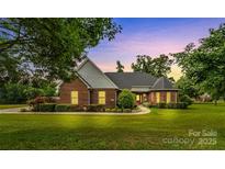 Beautiful brick home featuring a manicured lawn and lush landscaping, perfect for suburban living at 1825 Smyre Farm Rd, Newton, NC 28658