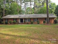 Charming brick ranch home with a well-manicured lawn and mature trees, offering great curb appeal at 3316 Mckee Rd, Charlotte, NC 28270