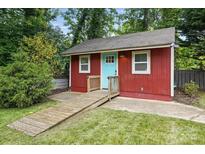 Cozy backyard studio with red siding, a bright blue door, and a convenient ramp at 4235 Howie Cir, Charlotte, NC 28205