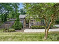 Charming stone home with a well-manicured front yard and inviting covered porch at 4235 Howie Cir, Charlotte, NC 28205