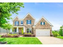 Charming brick home with a well-manicured lawn and a bright yellow front door at 5366 Meadowcroft Way, Fort Mill, SC 29708