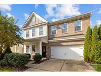 Charming two-story home with a brick and vinyl exterior, featuring an attached two-car garage at 6119 Castlecove Rd, Charlotte, NC 28278
