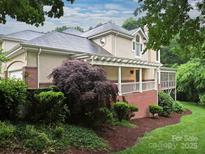Charming home with a lush landscaped yard and a covered porch, perfect for relaxing outdoors at 6647 Gaywind Dr, Charlotte, NC 28226
