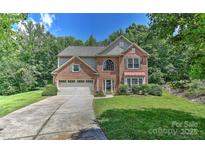 Charming two-story brick home with a well-manicured lawn and a two-car attached garage at 705 Moss Creek Dr, Matthews, NC 28105