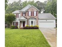 Charming two-story brick home with red shutters and well-manicured lawn at 10322 Stoneykirk Ln, Charlotte, NC 28269