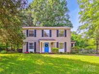 Charming two-story home featuring a bright blue door, black shutters, and a well-maintained front lawn at 11718 Battery Pl, Charlotte, NC 28273