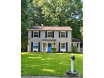 Charming two-story home featuring a blue front door and well-maintained lawn and traditional black shutters at 11718 Battery Pl, Charlotte, NC 28273