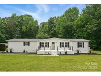 Charming single-story home featuring a well-manicured lawn and classic design at 12382 Ritchie Rd, Midland, NC 28107