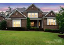Charming brick home featuring a well-manicured lawn, and manicured landscaping at 13102 Indigo Run Ct, Charlotte, NC 28278