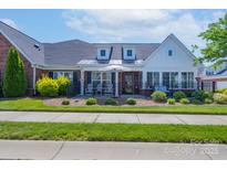 Charming brick home with a manicured lawn, black fence, and inviting front porch seating area at 148 Adelaide Way, Rock Hill, SC 29732
