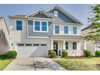 Charming two-story home with a well-manicured lawn, two-car garage and inviting front porch at 1553 Arcadia Bluff Dr, York, SC 29745