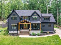 Stunning two-story home with dark siding, light-wood accents, manicured lawn, and inviting front porch at 167 Greenbay Rd, Mooresville, NC 28117