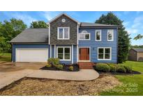 Charming two-story home with blue siding, stone accents, well-manicured landscaping, and an attached two-car garage at 2532 Steeplechase Rd, Gastonia, NC 28056