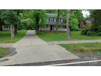 Charming two-story home with a spacious front yard and a welcoming front porch perfect for relaxing at 2716 Rea Rd, Charlotte, NC 28226