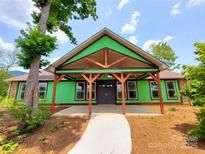 New construction home featuring a covered porch with timber beams and a stone accent wall at 401 Constant Ln, Charlotte, NC 28722