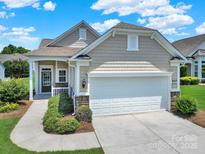 Charming home features a two-car garage, neutral siding, stone accents, and a well-manicured lawn at 4044 Murray St, Indian Land, SC 29707