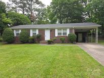 Charming brick house featuring a well-kept lawn and attached carport at 409 Anne Ave, Waxhaw, NC 28173