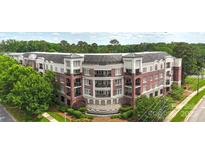 Beautiful brick condo building featuring private balconies and lush landscaping for a serene living experience at 5425 Closeburn Rd # 208, Charlotte, NC 28210