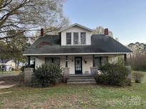Charming two-story home with a cozy front porch and mature landscaping at 562 W Wilson Ave, Mooresville, NC 28115