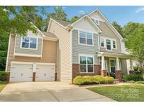 Two-story home with a two car garage, brick accents, and mature landscaping in a suburban neighborhood at 5812 Dinsmore Ln, Belmont, NC 28012