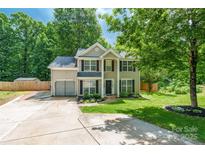 Charming two-story home featuring a well-manicured lawn, a driveway, and lush trees in a desirable neighborhood at 7206 Stoney Place Ct, Charlotte, NC 28262