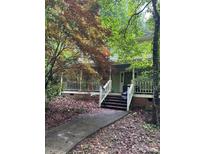 Charming home featuring a wide front porch and mature trees, creating a serene and inviting outdoor space at 8504 Knollwood Cir, Charlotte, NC 28213