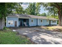 Charming one-story home with a blue exterior, lush greenery and large driveway at 875 Marys Grove Rd, Cherryville, NC 28021