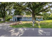 Charming blue single story home with mature trees and a welcoming front yard at 875 Marys Grove Rd, Cherryville, NC 28021