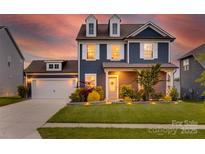 Charming two-story home with a landscaped lawn, dormer windows, and attached garage, perfect for curb appeal at 1033 Dorsey Dr, Fort Mill, SC 29715