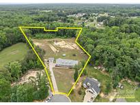 Expansive property with a beautiful home, pastures, and wooded areas all within defined yellow borders at 1230 Long Creek Ln, Salisbury, NC 28146