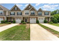 Charming townhomes featuring attached garages, manicured lawns, and stylish exterior finishes at 12408 Savannah Cottage Dr, Charlotte, NC 28273