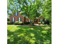 Charming brick home with a well-manicured lawn, mature trees, and classic architectural details at 1305 Yellowood Ct, Rock Hill, SC 29732