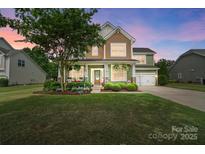 Charming two-story home with a well-manicured lawn, covered porch, and attached two-car garage at 132 Flora Vista Dr, Mooresville, NC 28117