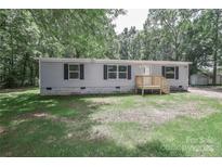 Charming single-story home with a gray exterior, black shutters, and a wooden porch at 1380 St. Johns Church Rd, Concord, NC 28025