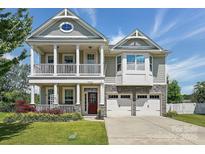 Inviting two-story home featuring a charming porch, a two car garage, and manicured lawn at 1437 Imperial Ct, York, SC 29745