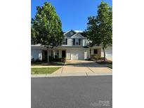 Charming townhome features a well-manicured lawn, driveway, and attached garage, surrounded by mature trees at 2009 Talbert Ct, Charlotte, NC 28214