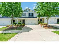 Exterior view of a townhouse with a driveway and lawn and large trees in front of each unit at 2009 Talbert Ct, Charlotte, NC 28214