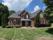 Beautiful brick home with manicured lawn and mature landscaping, providing great curb appeal at 2300 Lord Anson Dr, Waxhaw, NC 28173