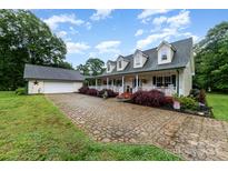 Charming two-story home featuring a large front porch, dormer windows, and a patterned driveway at 2451 Reepsville Rd, Lincolnton, NC 28092