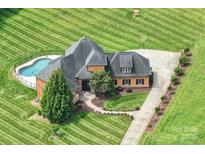 Aerial view of home boasts of a pool, basketball court, and manicured grounds at 270 Sandhills Ct, Mooresville, NC 28115