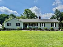 Charming single-story home with a well-manicured lawn, black shutters, and a cozy front porch at 2810 Elizabeth Ave, Shelby, NC 28150