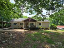 Charming single-story home with a cozy front porch and well-maintained lawn surrounded by mature trees at 29386 Nelson Mountain Rd, Albemarle, NC 28001