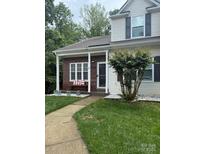 Charming home featuring a cozy front porch, brick accents, and well-maintained landscaping at 327 Wilkes Place Dr, Fort Mill, SC 29715