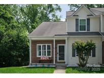 Charming two-story townhome with brick facade, well-kept lawn, and inviting front porch at 327 Wilkes Place Dr, Fort Mill, SC 29715