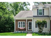 Charming townhouse with brick facade, covered entry, lovely landscaping, and inviting curb appeal at 327 Wilkes Place Dr, Fort Mill, SC 29715