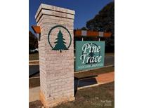 Welcoming brick sign for Pine Trace Neighborhood with its green tree logo in a circle, offering a friendly introduction at 4045 Port Richmond Ave # 10, Gastonia, NC 28056