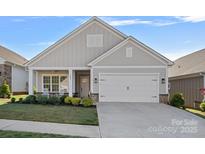 Charming single-Gathering home featuring a two-car garage and a well-manicured lawn with decorative shrubs at 4532 Stellata Loop, Sherrills Ford, NC 28673