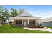 Charming brick home with a inviting front porch and a well-manicured lawn at 507 E Cloninger St, Dallas, NC 28034